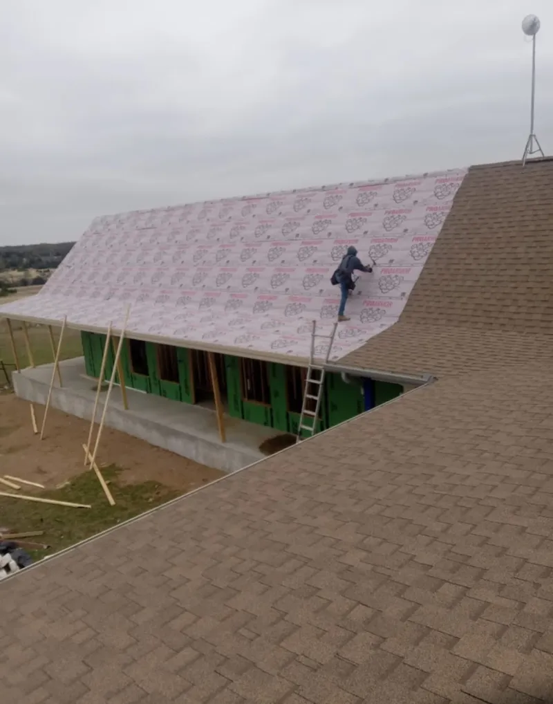 Worker preparing underlayment for a metal roof installation in Palmdale